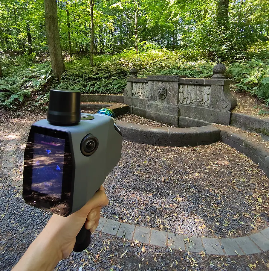 Handgeführter terrestrischer LiDAR-Sensor beim Scannen des Schillerbrunnens im Essener Stadtwald